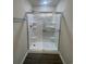 A spotless white fiberglass shower with glass doors and built-in shelves for convenient storage at 2247 Union Church Rd., Little River, SC 29566