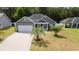 Charming single-story home with gray siding, well-manicured lawn, and a two-car garage at 247 Dempsey Dr., Loris, SC 29569
