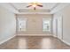 A sunlit bedroom with a tray ceiling, a ceiling fan, and elegant flooring that invites relaxation at 247 Dempsey Dr., Loris, SC 29569