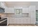 Bright kitchen featuring white cabinets, granite countertops, stainless steel appliances, and a window overlooking the yard at 247 Dempsey Dr., Loris, SC 29569