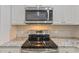 Close up of kitchen stainless steel electric stove top with granite countertops and stainless steel microwave at 247 Dempsey Dr., Loris, SC 29569