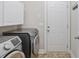 Laundry room with cabinets, stainless steel washer and dryer and door to backyard at 247 Dempsey Dr., Loris, SC 29569