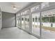 Enclosed sunroom with wall to wall sliding windows looking to a patio and fenced yard at 247 Dempsey Dr., Loris, SC 29569