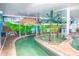 Indoor lazy river with lush foliage and tropical murals, perfect for relaxation at 3000 Ocean Blvd. N # 508, Myrtle Beach, SC 29577