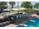 An outdoor pool bar with covered seating and sunny yellow accents is near a pool and sunbathing area at 3000 Ocean Blvd. N # 508, Myrtle Beach, SC 29577
