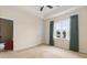 Cozy bedroom with a tray ceiling, window with curtains, and an open doorway at 334 Kiskadee Loop # 18-L, Conway, SC 29526