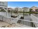 Dock featuring white railing overlooking calm waterway, and neighboring waterfront homes at 337 59Th Ave. N, North Myrtle Beach, SC 29582