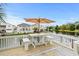 Waterfront deck featuring a white table and bench with umbrella and view of neighboring homes and waterway at 337 59Th Ave. N, North Myrtle Beach, SC 29582