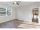 Bright bedroom featuring wood-look flooring, ceiling fan, and large window with view into the modern kitchen at 376 Black Pearl Way, Myrtle Beach, SC 29588