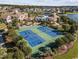 Aerial view of tennis courts and a pool surrounded by neighborhoods and a lake at 404 Plantation Oaks Dr., Myrtle Beach, SC 29579