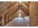 Unfinished attic space showcasing exposed rafters, plywood subfloor, and a window at 404 Plantation Oaks Dr., Myrtle Beach, SC 29579