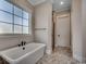 Modern bathroom with a soaking tub, walk-in shower, large window, and tile flooring at 404 Plantation Oaks Dr., Myrtle Beach, SC 29579