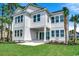 Backyard view of a modern farmhouse with a well manicured lawn and tropical landscaping at 404 Plantation Oaks Dr., Myrtle Beach, SC 29579