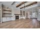 Spacious living room with a fireplace, wooden beams, custom shelving, and hardwood floors at 404 Plantation Oaks Dr., Myrtle Beach, SC 29579