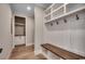 Organized mudroom featuring a built-in bench with hooks, storage cabinets, and wood flooring at 404 Plantation Oaks Dr., Myrtle Beach, SC 29579