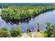 Aerial view showcases the riverfront property with mature trees, a private dock, and inviting outdoor amenities at 4074 Center Rd., Georgetown, SC 29440