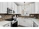 Bright kitchen features white cabinetry, stainless steel appliances, and modern backsplash at 4355 Willoughby Ln. # 401, Myrtle Beach, SC 29577