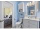 Charming bathroom with blue walls, white cabinets, and a view into the bedroom at 4737 Wild Iris Dr. # 203, Myrtle Beach, SC 29577