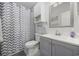 Modern bathroom with gray vanity, white toilet, and patterned shower curtain at 4737 Wild Iris Dr. # 203, Myrtle Beach, SC 29577