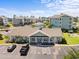 Aerial view of the community clubhouse with parking and landscaping near condo buildings at 4737 Wild Iris Dr. # 203, Myrtle Beach, SC 29577