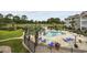 Community pool with blue lounge chairs, palm trees, lush landscaping, and golf course view at 4737 Wild Iris Dr. # 203, Myrtle Beach, SC 29577