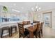 Open-concept dining area boasts a modern chandelier, a large clock, and views into the kitchen at 4737 Wild Iris Dr. # 203, Myrtle Beach, SC 29577