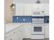 Well-lit kitchen features white cabinets, modern appliances, and stylish backsplash at 4737 Wild Iris Dr. # 203, Myrtle Beach, SC 29577