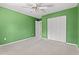 Bright, empty bedroom with green walls, a ceiling fan, neutral carpet, and a door to a closet at 480 Dandelion Ln., Myrtle Beach, SC 29579