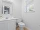 Clean powder room featuring a white vanity, toilet, and large mirror with natural light at 480 Dandelion Ln., Myrtle Beach, SC 29579