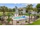 Outdoor pool with sundeck, lounge chairs, palm trees, and nearby condo buildings at 4828 Magnolia Lakes Dr. # 404, Myrtle Beach, SC 29577