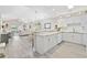 Bright open-concept kitchen with skylight, granite counters, white cabinets and stainless steel appliances overlooking living area at 4828 Magnolia Lakes Dr. # 404, Myrtle Beach, SC 29577