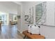 Hallway with decorative artwork and a woven bench leading into a light and airy living space at 489 Blissful Ln., Little River, SC 29566