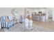 Bright, airy living space with modern furnishings, including striped chairs, area rug, and an open kitchen at 493 Blissful Ln., Little River, SC 29566