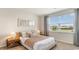 Bright bedroom features a large window, neutral decor, and cozy bedding, creating a relaxing and inviting atmosphere at 497 Blissful Ln., Little River, SC 29566