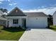 Charming single-story home featuring a two-car garage, manicured lawn, and inviting front porch at 497 Blissful Ln., Little River, SC 29566