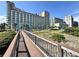 A captivating view of the resort from the wooden boardwalk with buildings and clear skies at 5200 N Ocean Blvd. # 640, Myrtle Beach, SC 29577