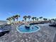 Outdoor kidney-shaped pool with sunning area and lounge chairs, with palm trees in the background at 5200 N Ocean Blvd. # 640, Myrtle Beach, SC 29577