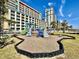 Community playground with climbing structures surrounded by tropical palm trees and landscaping at 5300 N Ocean Blvd. # 1102, Myrtle Beach, SC 29577
