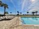 Scenic poolside view with lounge chairs and palm trees, a tranquil spot to soak up the sun at 5300 N Ocean Blvd. # 1102, Myrtle Beach, SC 29577