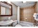 Bathroom with tub and shower, decorative framed mirror, toilet, sink and towels at 5300 N Ocean Blvd. # 410, Myrtle Beach, SC 29577