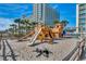 Exterior playground area with a large wooden ship play structure next to modern condos in a resort community at 5300 Ocean Blvd. N # 903, Myrtle Beach, SC 29577