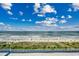 Stunning ocean view from condo balcony showcasing the beach, blue water, and a partly cloudy sky at 5300 Ocean Blvd. N # 903, Myrtle Beach, SC 29577