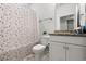Stylish bathroom featuring decorative wallpaper, white toilet, and vanity with storage at 57 Eagle Claw Dr., Carolina Shores, NC 28467