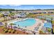 Aerial view of community pool with ample seating, a covered pavilion, and landscaping at 57 Eagle Claw Dr., Carolina Shores, NC 28467