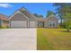 Charming home featuring a two-car garage, manicured lawn, and inviting entrance at 57 Eagle Claw Dr., Carolina Shores, NC 28467