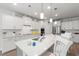 Gourmet kitchen boasts white cabinets, quartz countertops, pendant lighting, and modern appliances at 57 Eagle Claw Dr., Carolina Shores, NC 28467