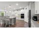 Modern kitchen with white cabinetry, stainless steel appliances, an island with bar seating, and wood floors at 57 Eagle Claw Dr., Carolina Shores, NC 28467