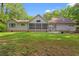 Exterior of home with a screen porch, brick foundation, and lush lawn at 57 River Birch Ln., Pawleys Island, SC 29585