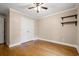 A clean bedroom features hardwood flooring, ceiling fan, crown molding, and a closet for storage at 57 River Birch Ln., Pawleys Island, SC 29585