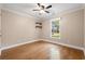 A bright bedroom featuring hardwood flooring, ceiling fan, a window with exterior views, and modern shelving at 57 River Birch Ln., Pawleys Island, SC 29585